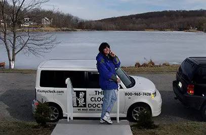 A woman standing next to a van on the side of a road.