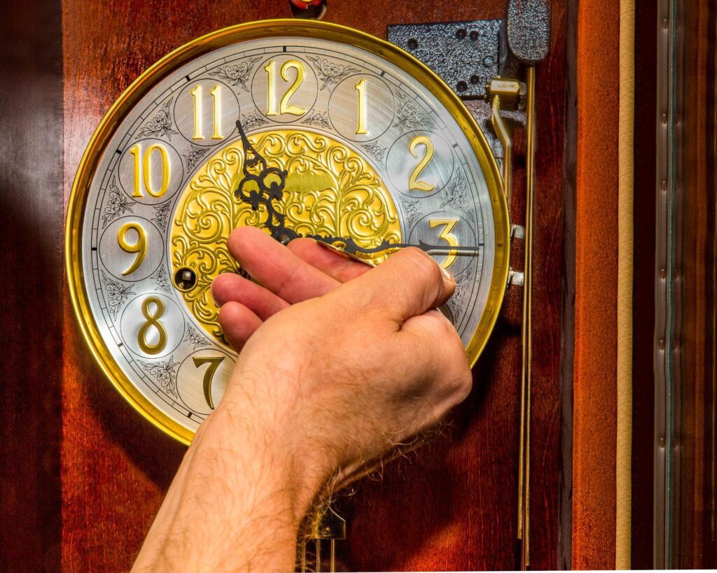 a hand touching an antique clock