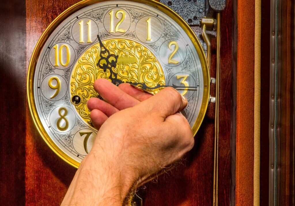 Hand winding a vintage clock face.