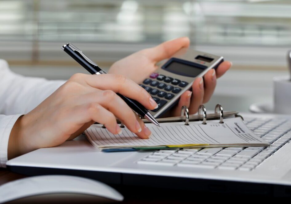 a person using a pen and calculator